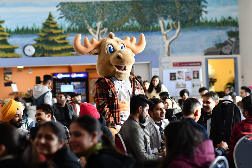 Group of ʿ students with moose mascot in cafeteria